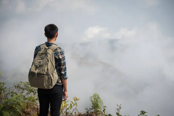 Hiker with backpacks standing on top of a mountain and enjoying nature view.