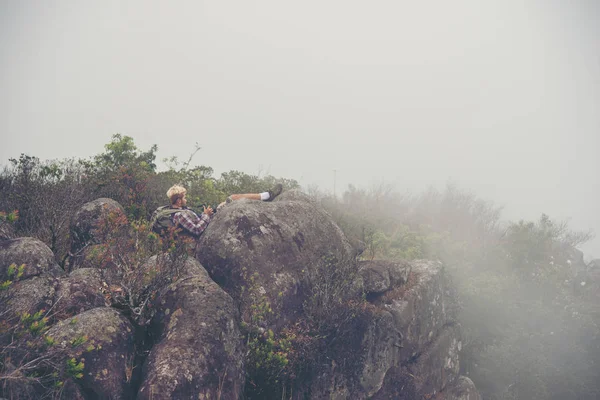 Hiker with backpacks standing on top of a mountain and enjoying nature view.