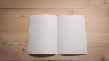 Ahşap masa üstünde beyaz boş kağıt not etmek.