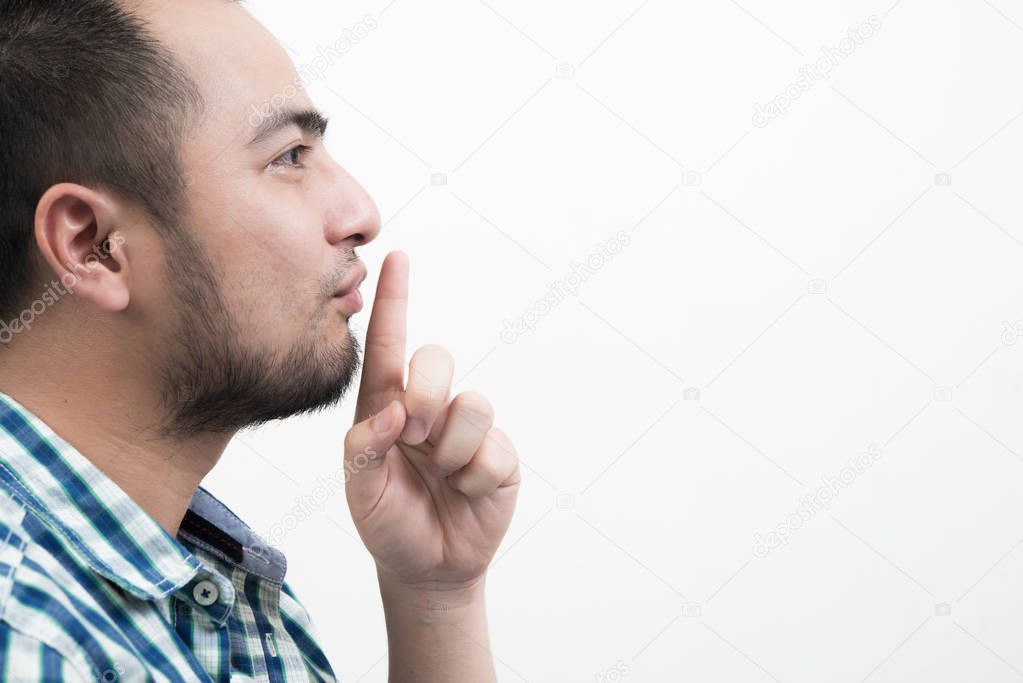Young man making silence gesture isolated on white background