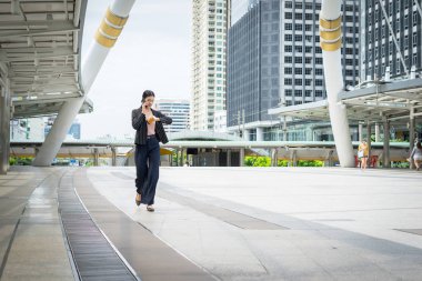 Cep telefonu hakkını izle sokakta seyir ofis binaları içinde belgili tanımlık geçmiş ile konuşurken yürüyüş iş kadını