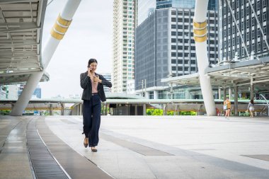 Cep telefonu hakkını izle sokakta seyir ofis binaları içinde belgili tanımlık geçmiş ile konuşurken yürüyüş iş kadını