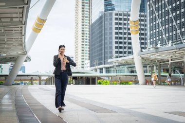 Cep telefonu hakkını izle sokakta seyir ofis binaları içinde belgili tanımlık geçmiş ile konuşurken yürüyüş iş kadını