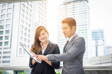 Belge gülümseme ile işaret ve bir şey onu iş arkadaşınız ofis önünde duran süre ile tartışırken iş adamı.