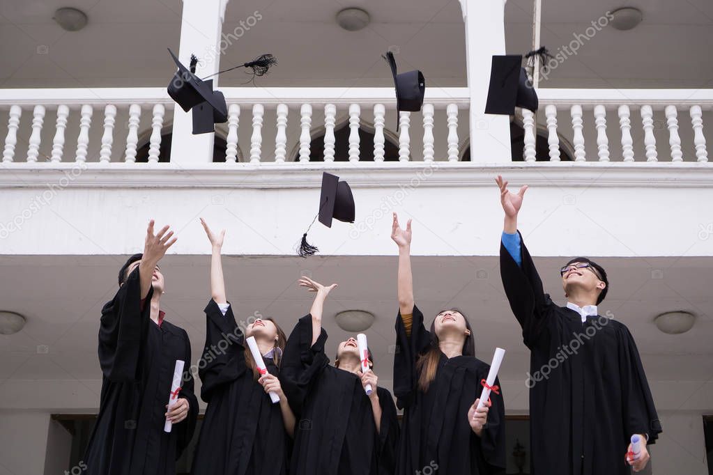 Group of Successful students with congratulations together throwing graduation hats in the air and celebrating. Education concept.