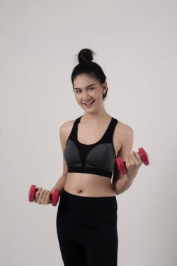 Beyaz arka plan üzerinde izole dumbbells ile tutan genç güzel kadın.