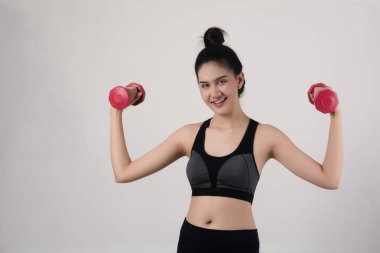 Beyaz arka plan üzerinde izole dumbbells ile tutan genç güzel kadın.