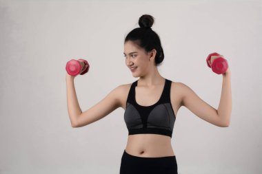 Beyaz arka plan üzerinde izole dumbbells ile tutan genç güzel kadın.