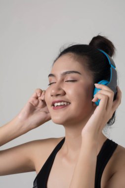 Mutlu genç kadın beyaz arka plan üzerinde izole kulaklık müzik dinlemek