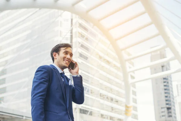 Businessman talking on cell phone against the building outdoors