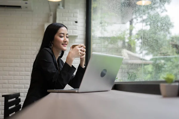 Young business woman have a break with coffee while working on laptop in the office