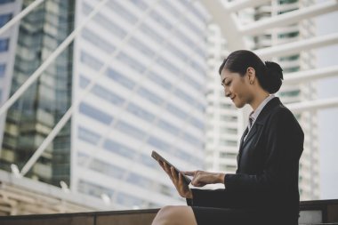 Dizüstü bilgisayar kullanan merdiven üzerinde oturan bir genç bayan. Açık bir dizüstü bilgisayar üzerinde çalışan erkek 