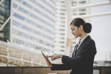 Dizüstü bilgisayar kullanan merdiven üzerinde oturan bir genç bayan. Açık bir dizüstü bilgisayar üzerinde çalışan erkek 