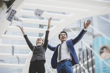 İş adamları belgeler, ofis binası önünde dururken yukarı atma vardır. İş başarıyla kavramı.