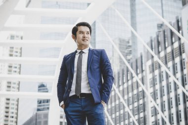 İş Merkezi cephesinde duran mutlu işadamı portresi.