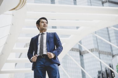 İş Merkezi cephesinde duran mutlu işadamı portresi.