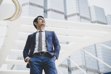İş Merkezi cephesinde duran mutlu işadamı portresi.