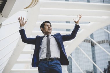 İş Merkezi cephesinde duran mutlu işadamı portresi.