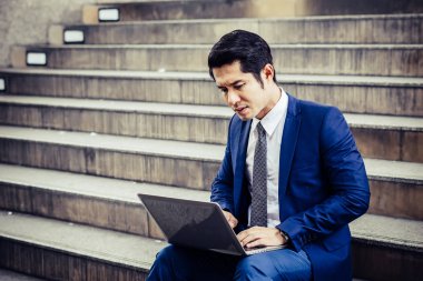 Laptop ile çalışma merdiven üzerinde oturan hayal kırıklığına uğramış genç adam. Çalışmaları ile mutsuz ilgili sorun.