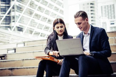 Yeni fikirleri tartışmak ve merdiven memur üzerinde oturan laptop beyin fırtınası iş arkadaşları