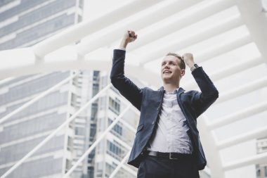 Başarılı bir şekilde genç işadamı silah kaldırdı ve ifade pozitif açık havada süre ayakta tutmak