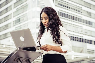 Dizüstü bilgisayar kullanan merdiven üzerinde oturan bir genç bayan. Açık bir dizüstü bilgisayar üzerinde çalışan erkek 