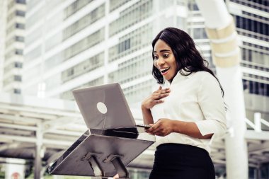 Dizüstü bilgisayar kullanan merdiven üzerinde oturan bir genç bayan. Açık bir dizüstü bilgisayar üzerinde çalışan erkek 