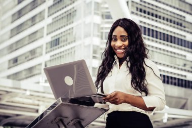 Dizüstü bilgisayar kullanan merdiven üzerinde oturan bir genç bayan. Açık bir dizüstü bilgisayar üzerinde çalışan erkek 