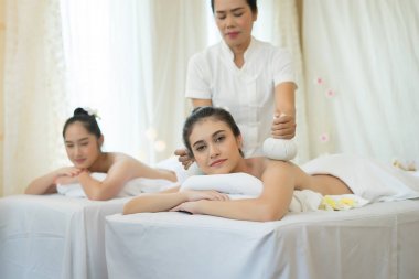 İki sevimli genç kadın Spa'da masaj sırasında rahatlatıcı keyfini çıkarın.