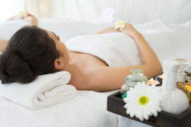 Asyalı güzel kadın yalan rahatlamak için spa beyaz yatakta 