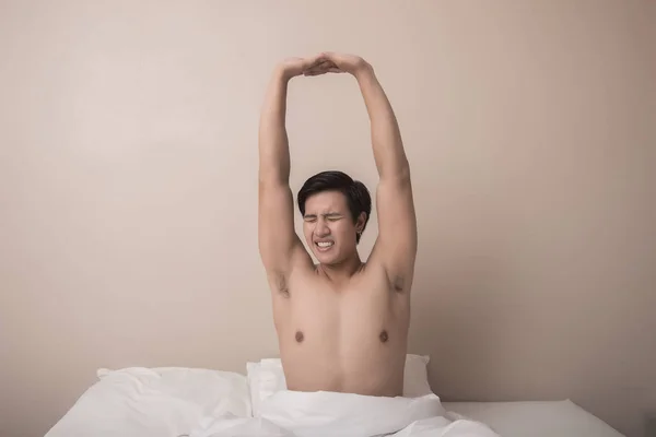 Bonito Homem Sorrindo Enquanto Estende Sua Cama Casa — Fotografia de Stock