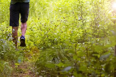 Yolda yürüyen genç bir adamın ayakları. Yaz, İlkbahar, Sonbahar.