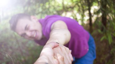 Genç adam kızın elini çeker. Orman. Yaz.