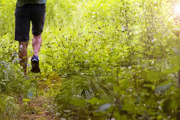 Yolda yürüyen genç bir adamın ayakları. Yaz, İlkbahar, Sonbahar.