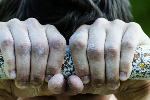 young man holding hands on the horizontal bar