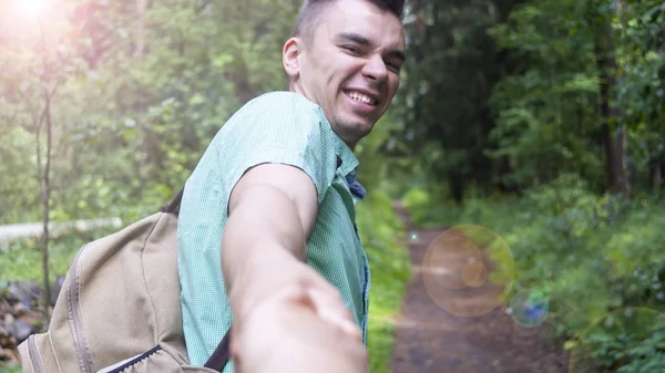 Den unge mannen drar flickans hand på skogsstigen — Stockfoto