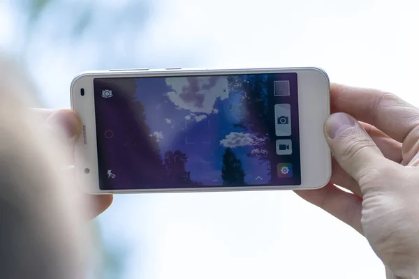 Minsk, Beyaz Rusya, Temmuz/08/2017: Bir adam gökyüzüne telefon çekiyor