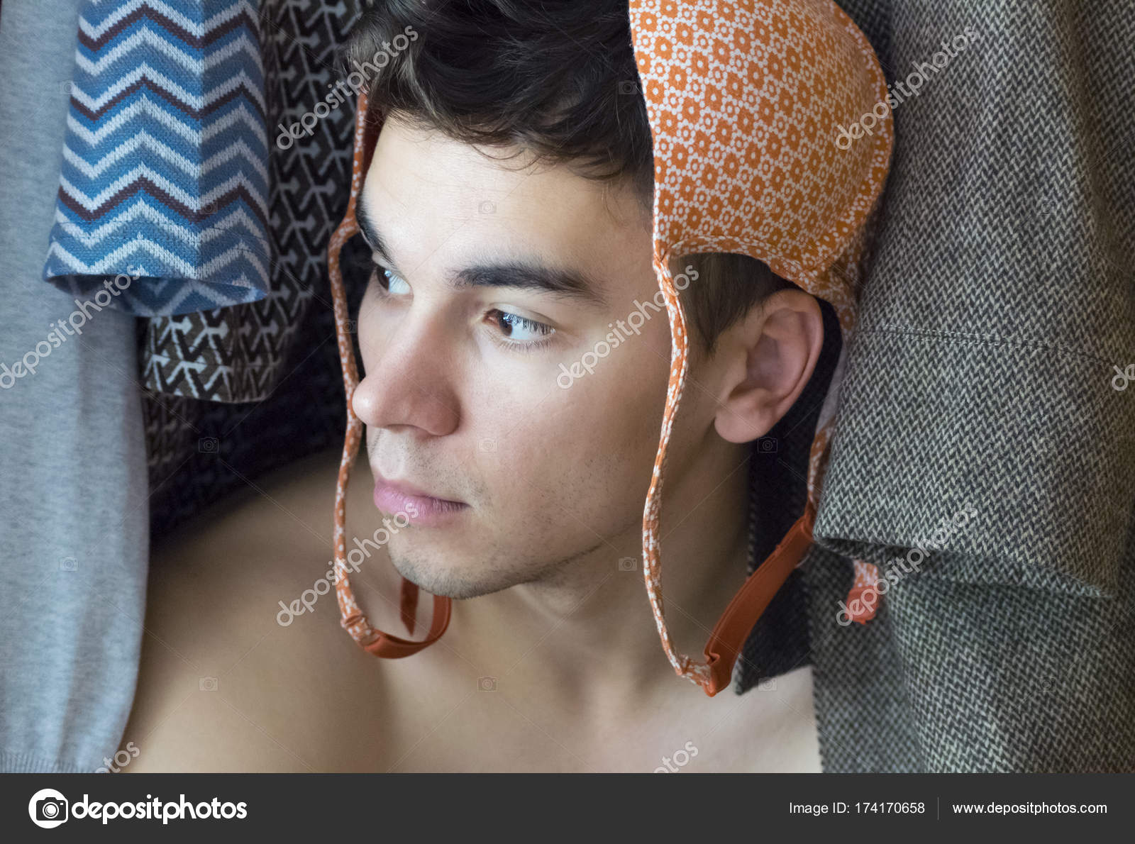A young man with bra on his head is hiding in the closet Stock Photo by  ©katederr 174170658