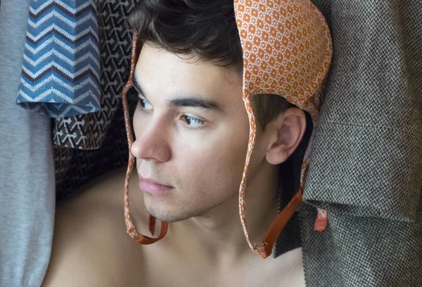 Kafasında bir sutyen ile genç bir adam dolapta saklanıyor