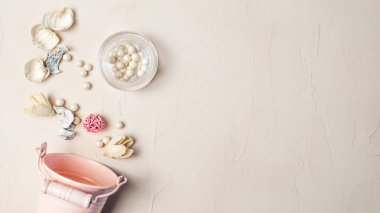 Dekoratif kova, allık, kuru ot, pembe top. Pastel renkli natürmort.