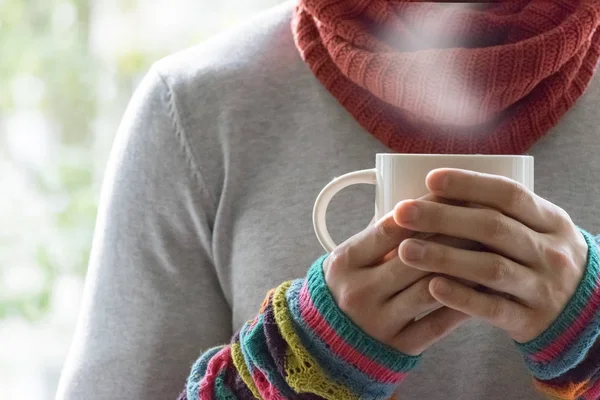 Bir fincan çay ve limon tutan genç bir adam. Soğuk, soğuk, hastalık.