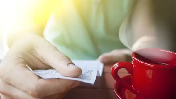 Un hombre sosteniendo la cuenta en un café — Foto de Stock