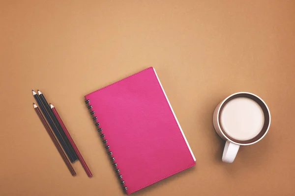 Reloj despertador, cuaderno, lápices sobre fondo rosa — Foto de Stock