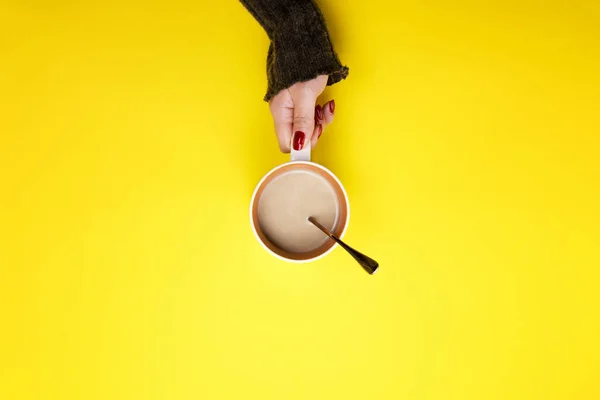 Fille tenant une tasse de café sur un fond jaune. Le concept de pause, de pause . — Photo