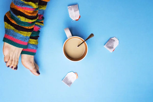 Flicka i strumpor och omgiven av kaffe och te. Begreppet stopp för kaffepauser. Drycker. — Stockfoto