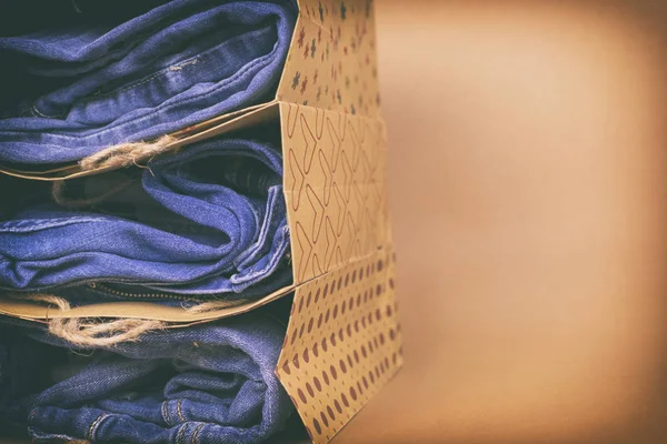 Vrouwen jeans gevouwen in een stapel op een gekleurde achtergrond. Gemaakt in een vintage prestaties. — Stockfoto