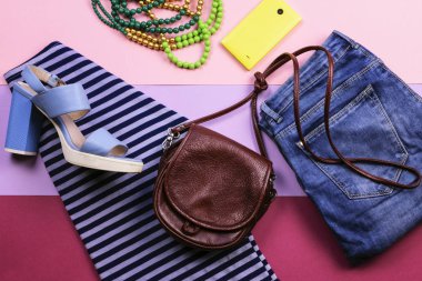 Parlak kadın aksesuarları ve giyim leylak bir arka plan üzerinde. Üstten Görünüm. Düz yatıyordu.