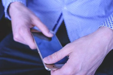 Genç bir adam parlak gömlekli Smartphone yazışma mevcuttur. Kavram Yöneticisi ve iş adamı.