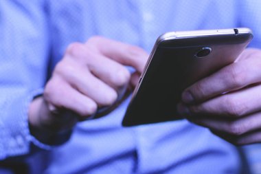 Genç bir adam parlak gömlekli Smartphone yazışma mevcuttur. Kavram Yöneticisi ve iş adamı.