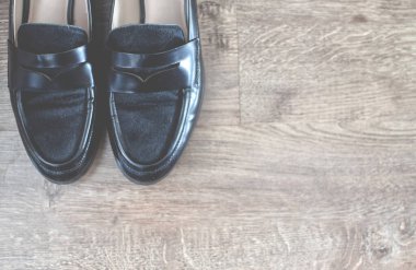 Mokasen ve diğer ayakkabılar eski tarz tahta zeminde duruyor..